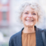 A woman is happy despite dealing with senior incontinence due to managing it as best she can.