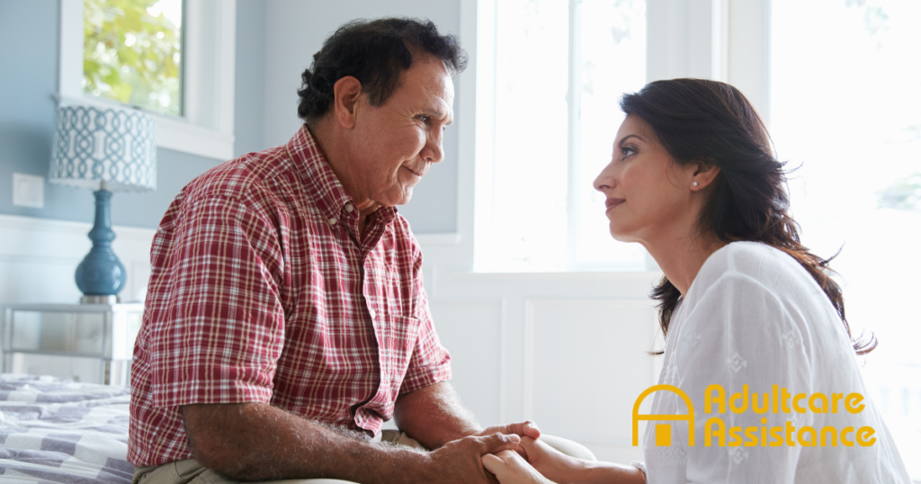 A daughter who is caregiving for her dad who has Alzheimer’s disease, lovingly holds his hands.
