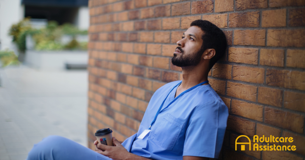 An exhausted professional caregiver takes a break outside.