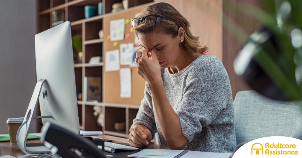 A woman is exhausted at her job as a result of struggling with balancing caregiving and her career.
