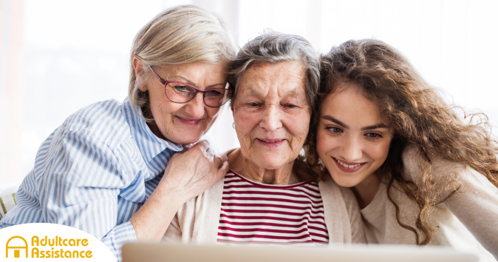 Three generations embrace and look at a computer, representing the sandwich generation.